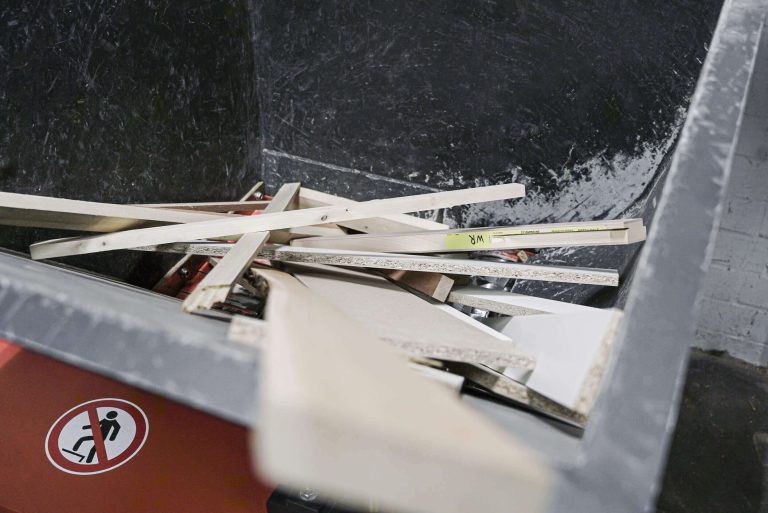 a top-down view into a machine hopper filled with wood waste pieces