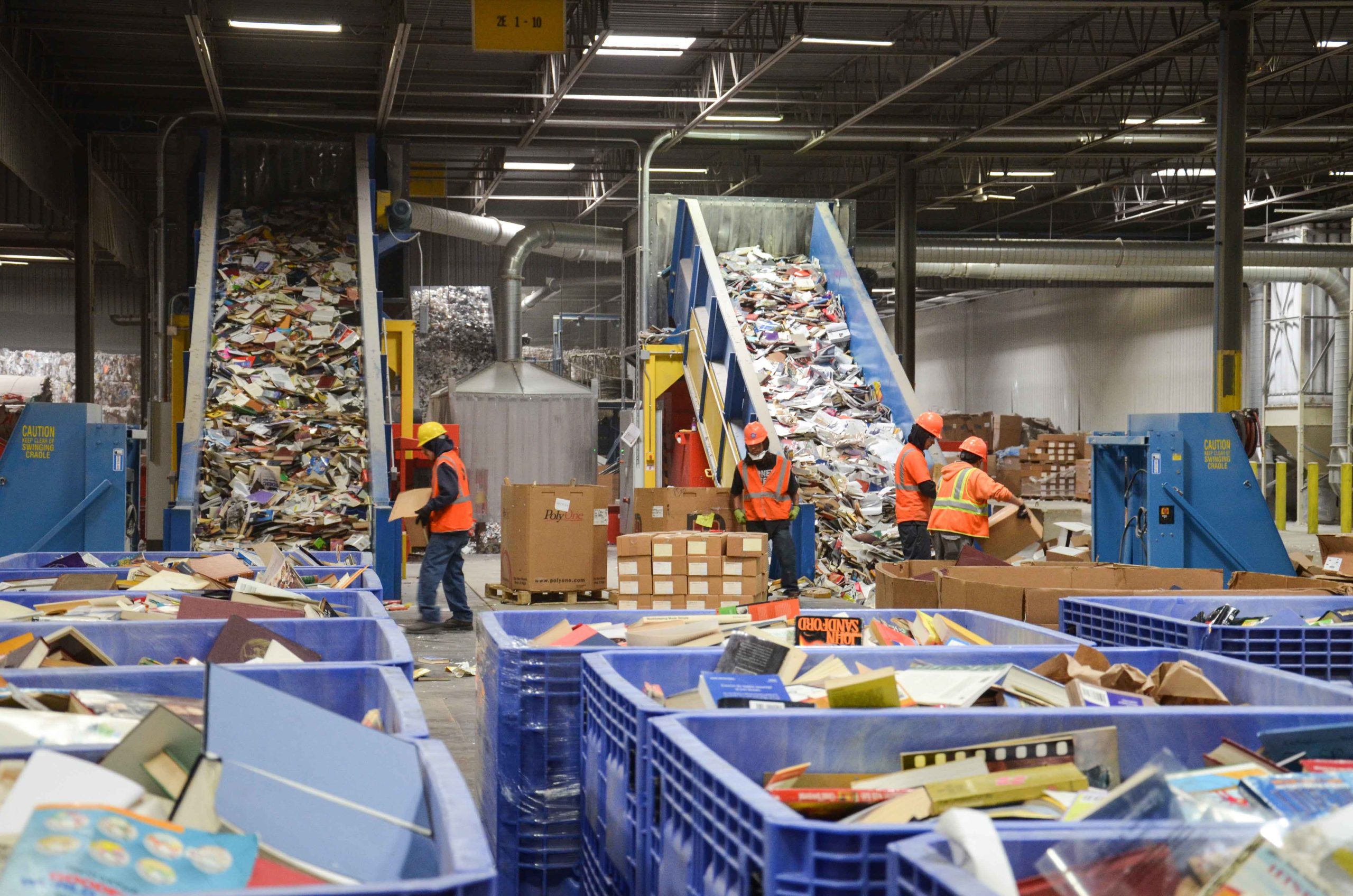 Bücher werden mit Förderbänder in zwei WEIMA Shredder gefördert.