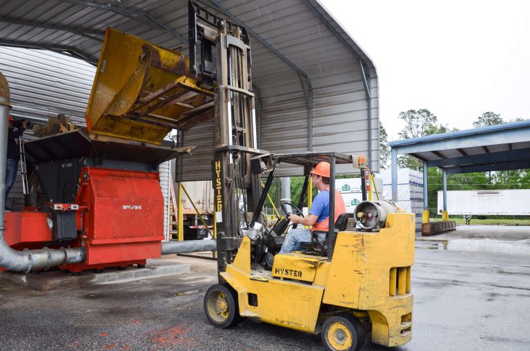 Forklift truck tips wood waste into WEIMA WLK 15 shredder