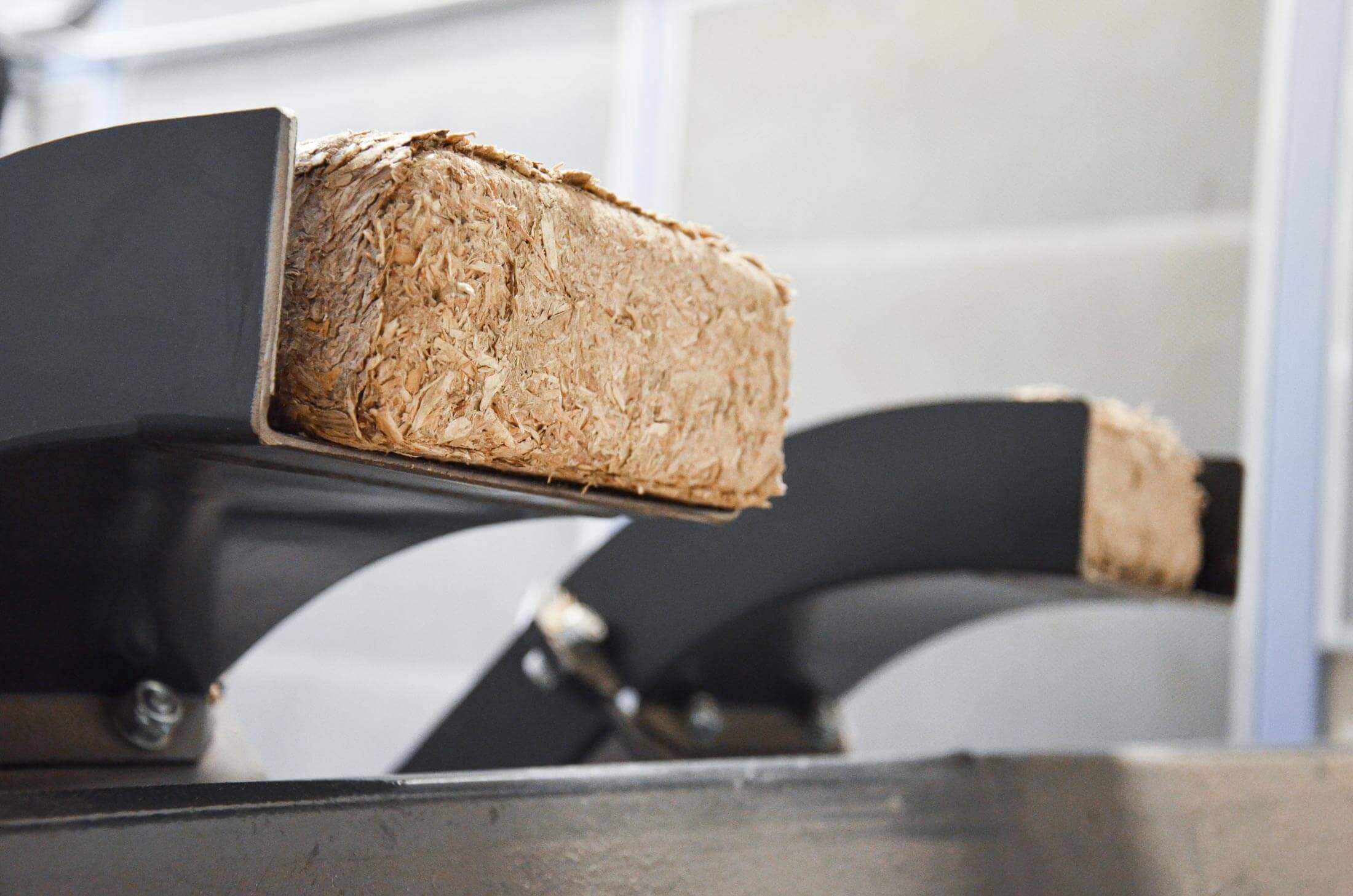 Square wood briquettes are ejected from the WEIMA briquette press