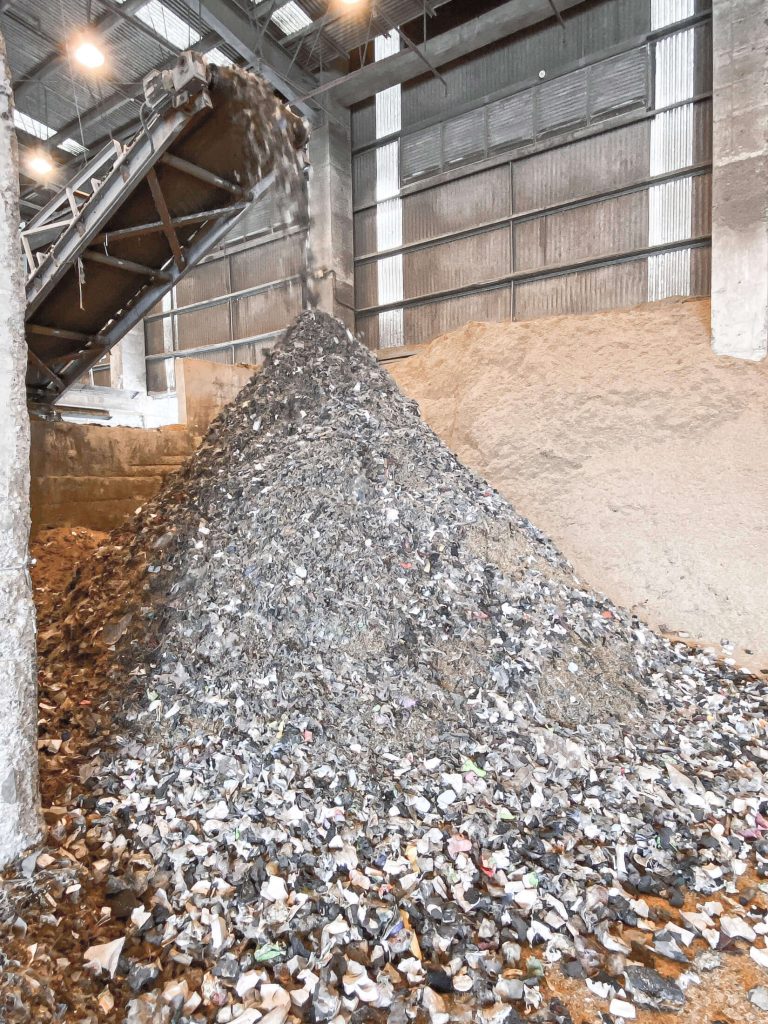 Shredded hazardous waste is transported by conveyor belt system