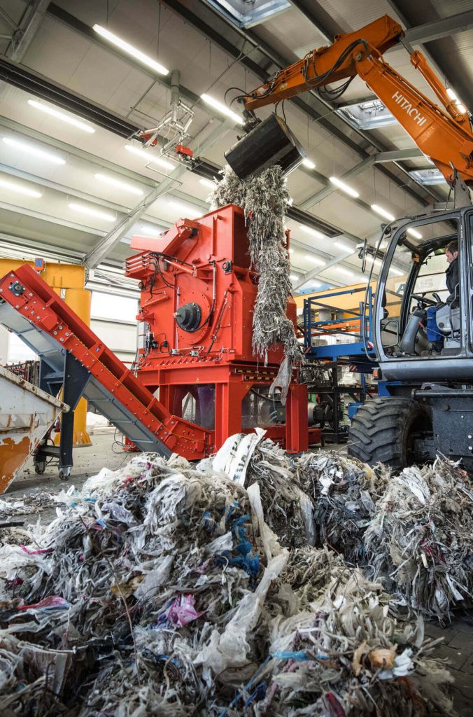 Pulper Waste Rejects Beschickung durch einen Bagger in WEIMA Einwellen-Zerkleinerer