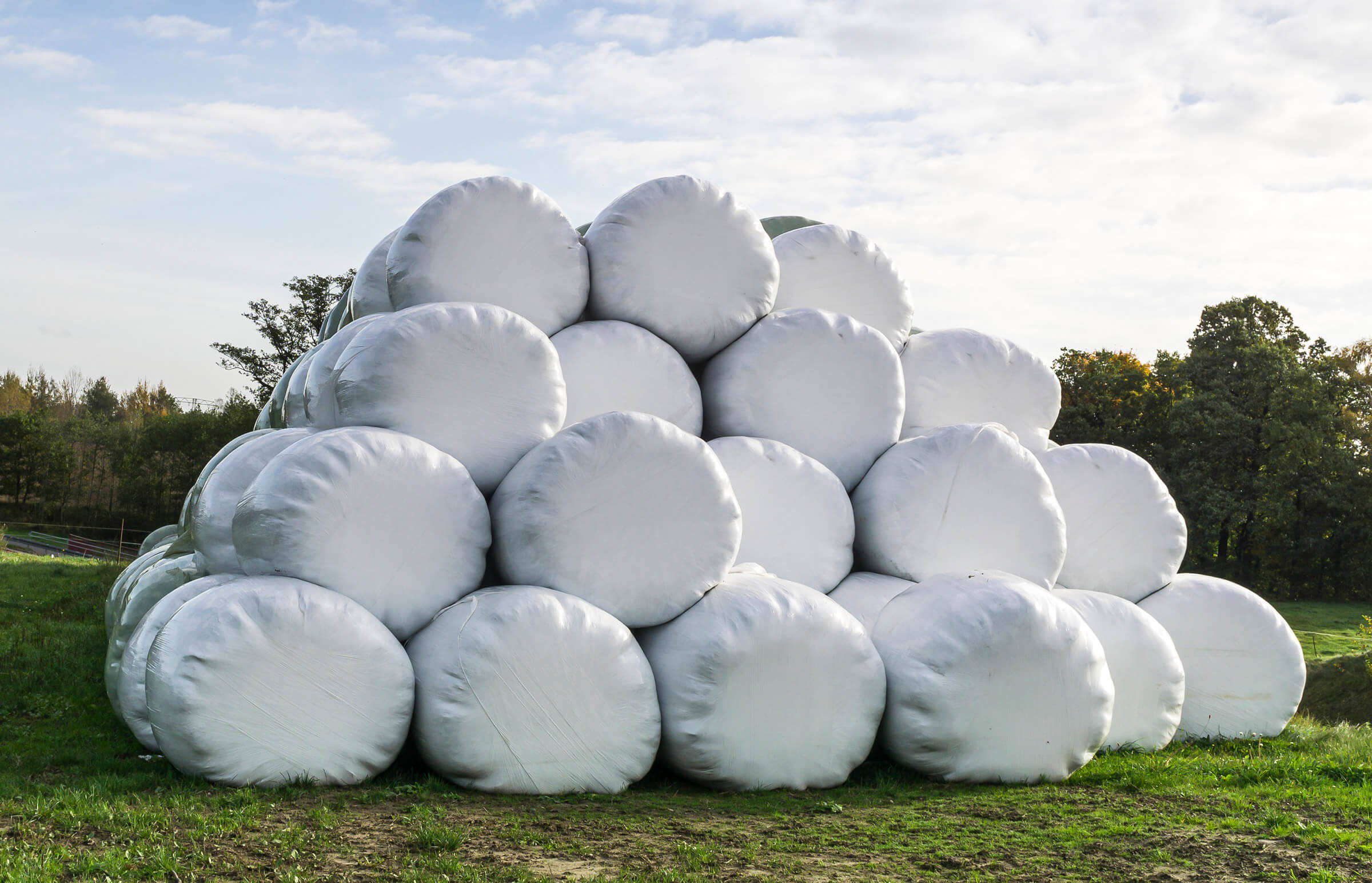 Haufen mit Wickelfolien Ballen auf dem Feld für Futtererzeugung