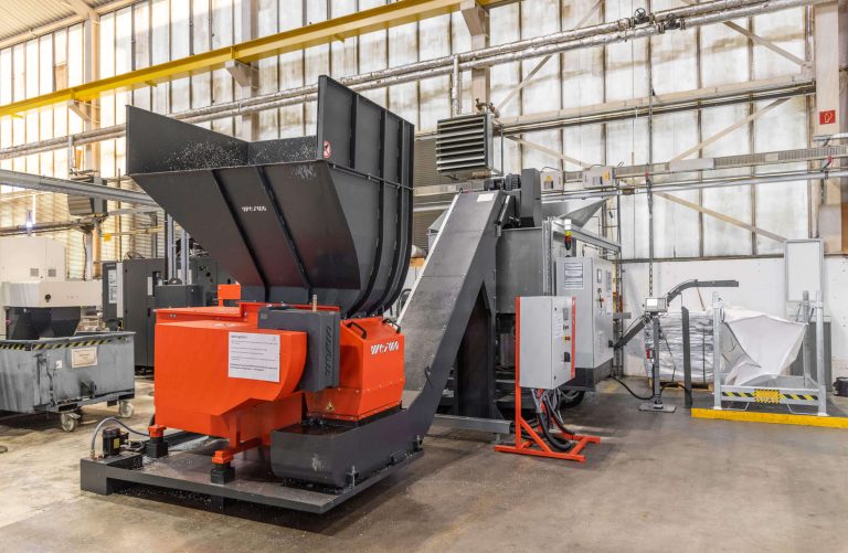 A WEIMA shredder whose output is fed directly from the conveyor belt into the press.