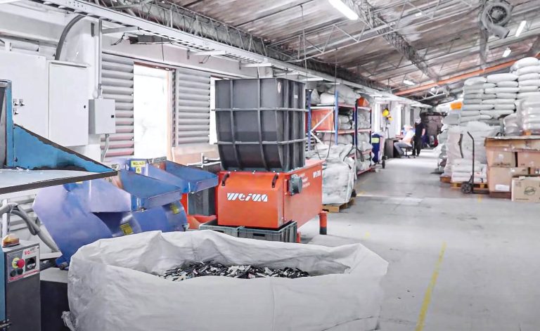 orange WEIMA shredder with shredded plastic in big bag at plasticos ojara production hall