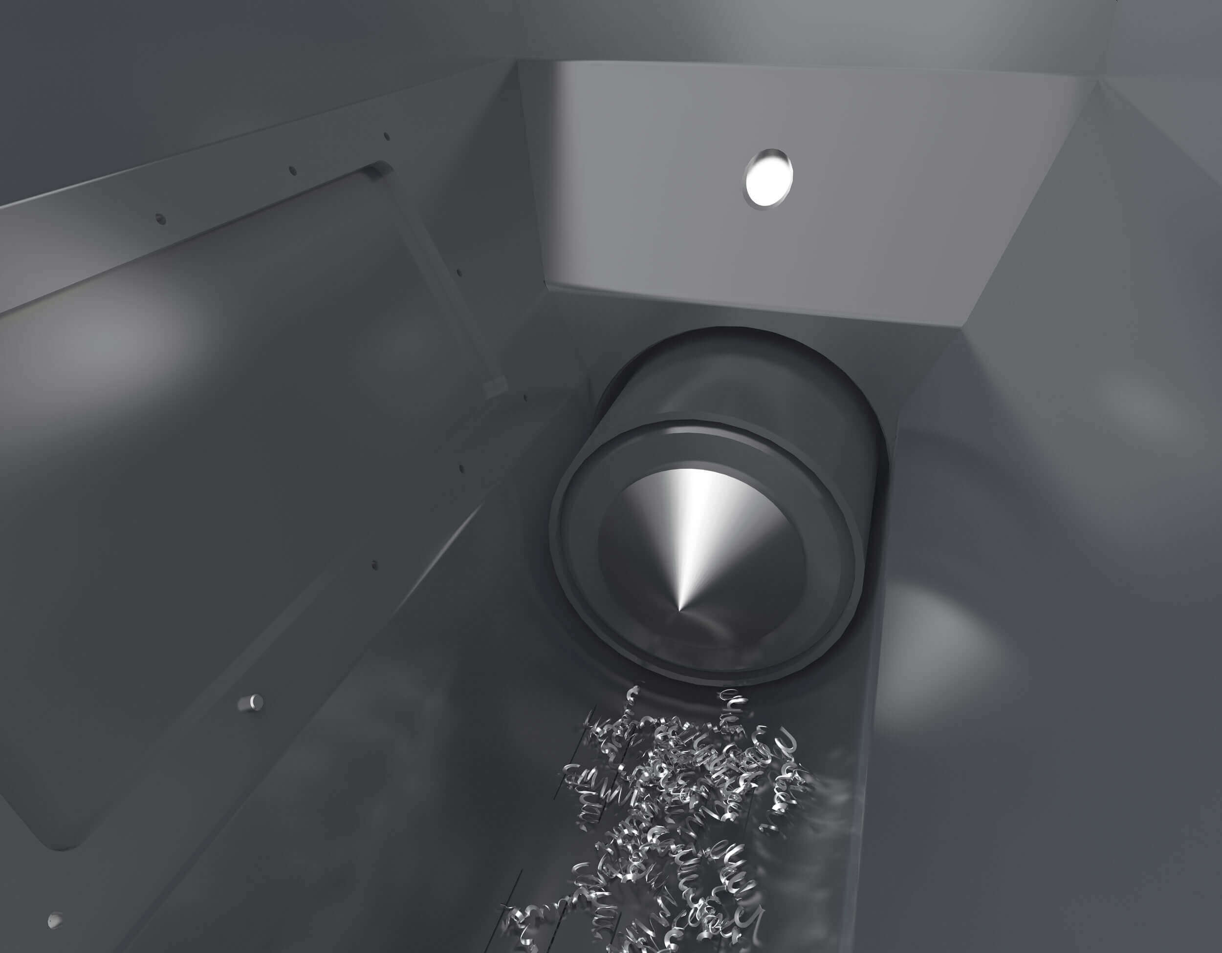 In the hopper, ball-like metal chips and level sensors can be seen next to the press die.