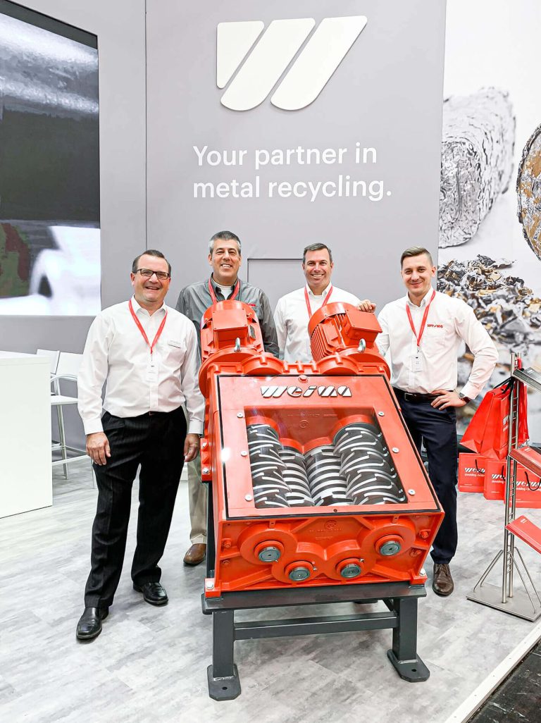 four weima employees behind and next to a weima four shaft shredder