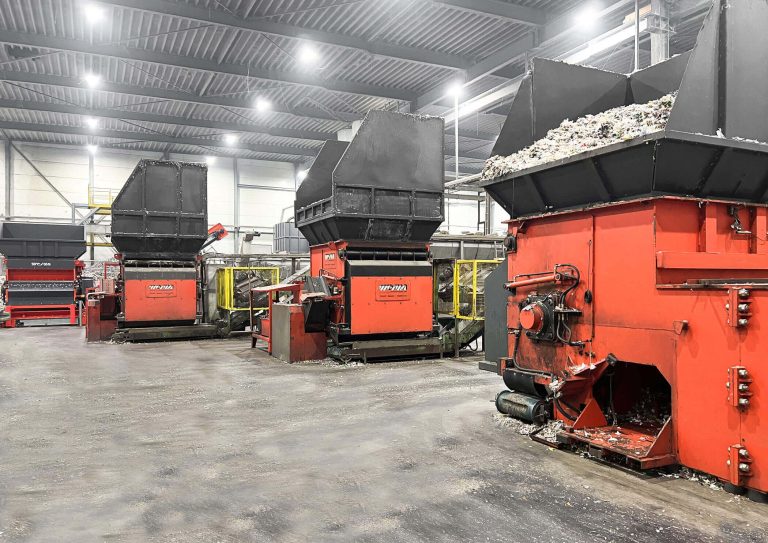 Four WEIMA shredders in a row in a large hall.