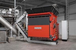 orangefarbener WEIMA S7.20 Einwellen-Zerkleinerer mit Förderband bei Stiphout Plastics in den Niederlanden