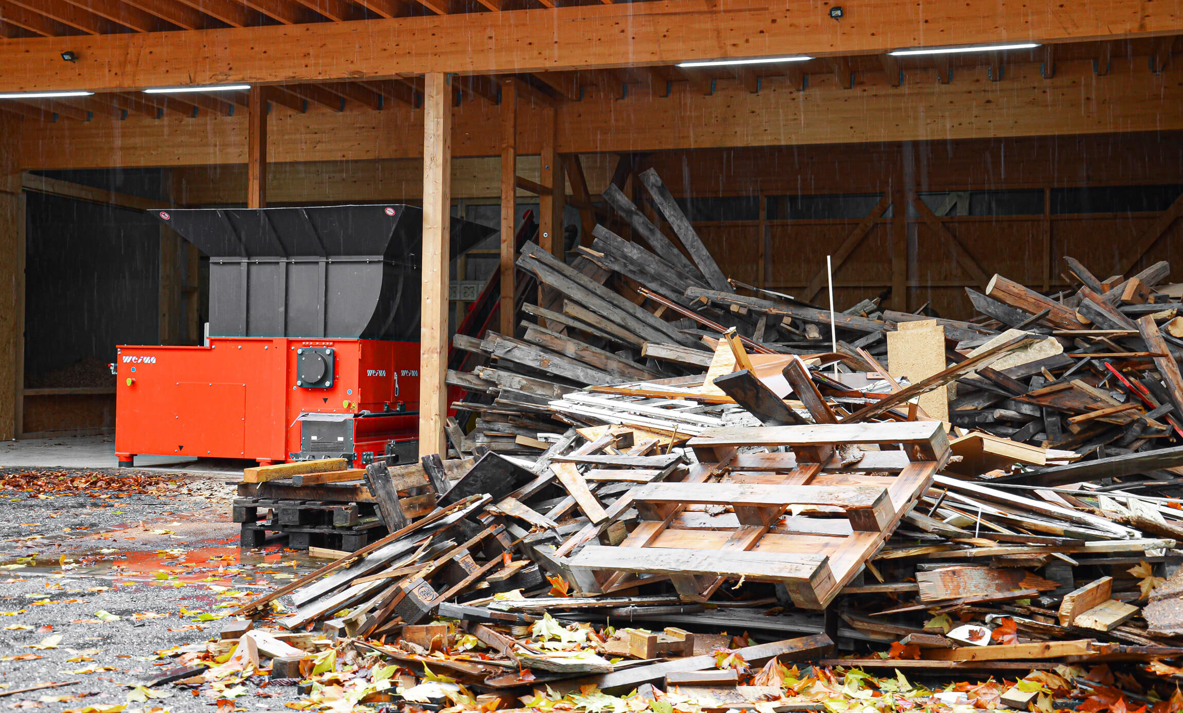 WEIMA Shredder neben Haufen aus Altholz