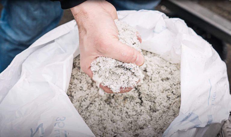 Hand holding wet recycling plastic fines