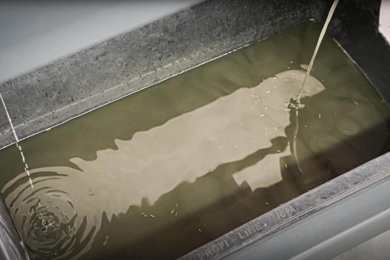 Emulsion fließt in Auffangwanne aus Metall