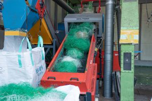 Loaded shredder conveyor belt with fishing nets
