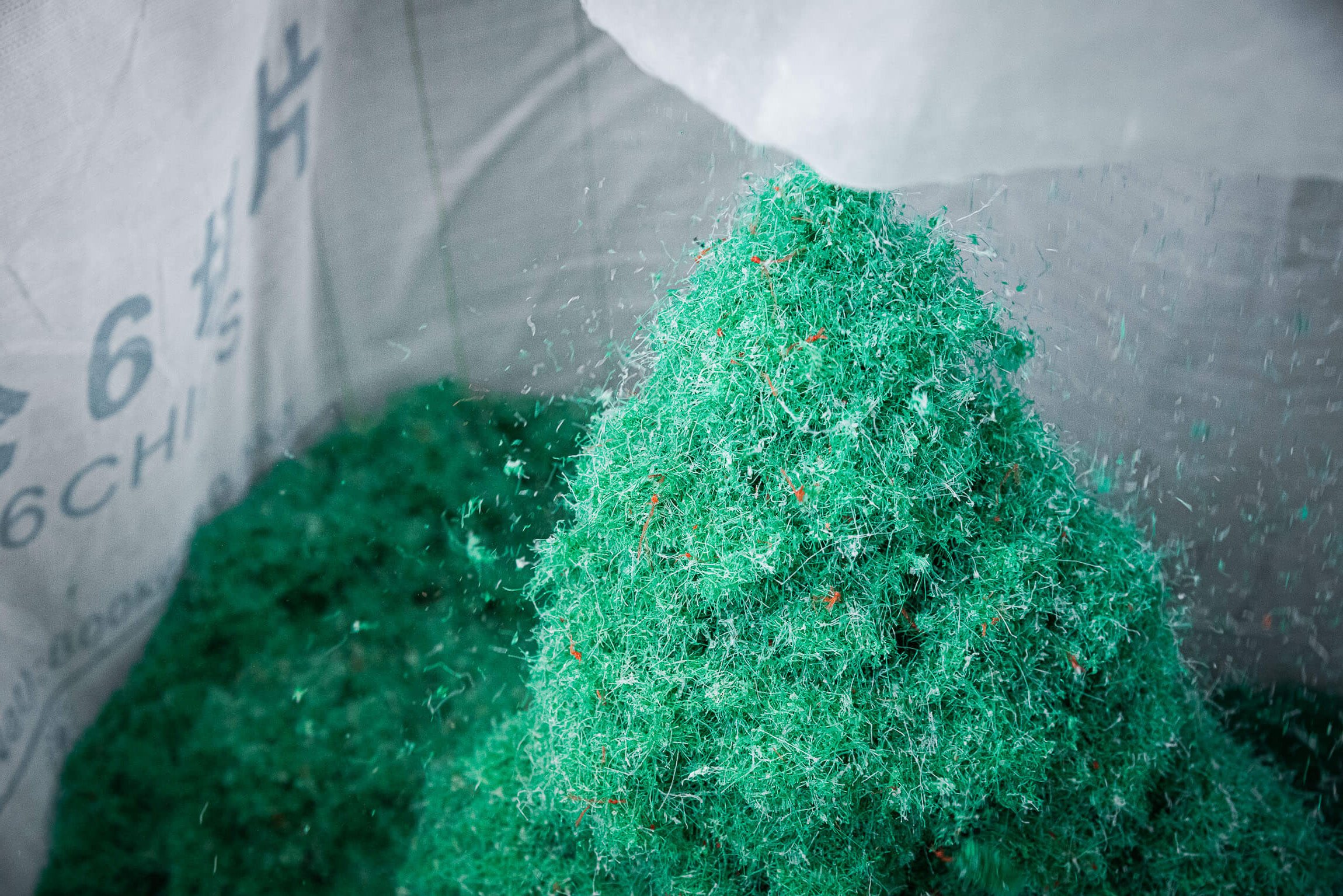 Green shredded fishing nets in a big bag