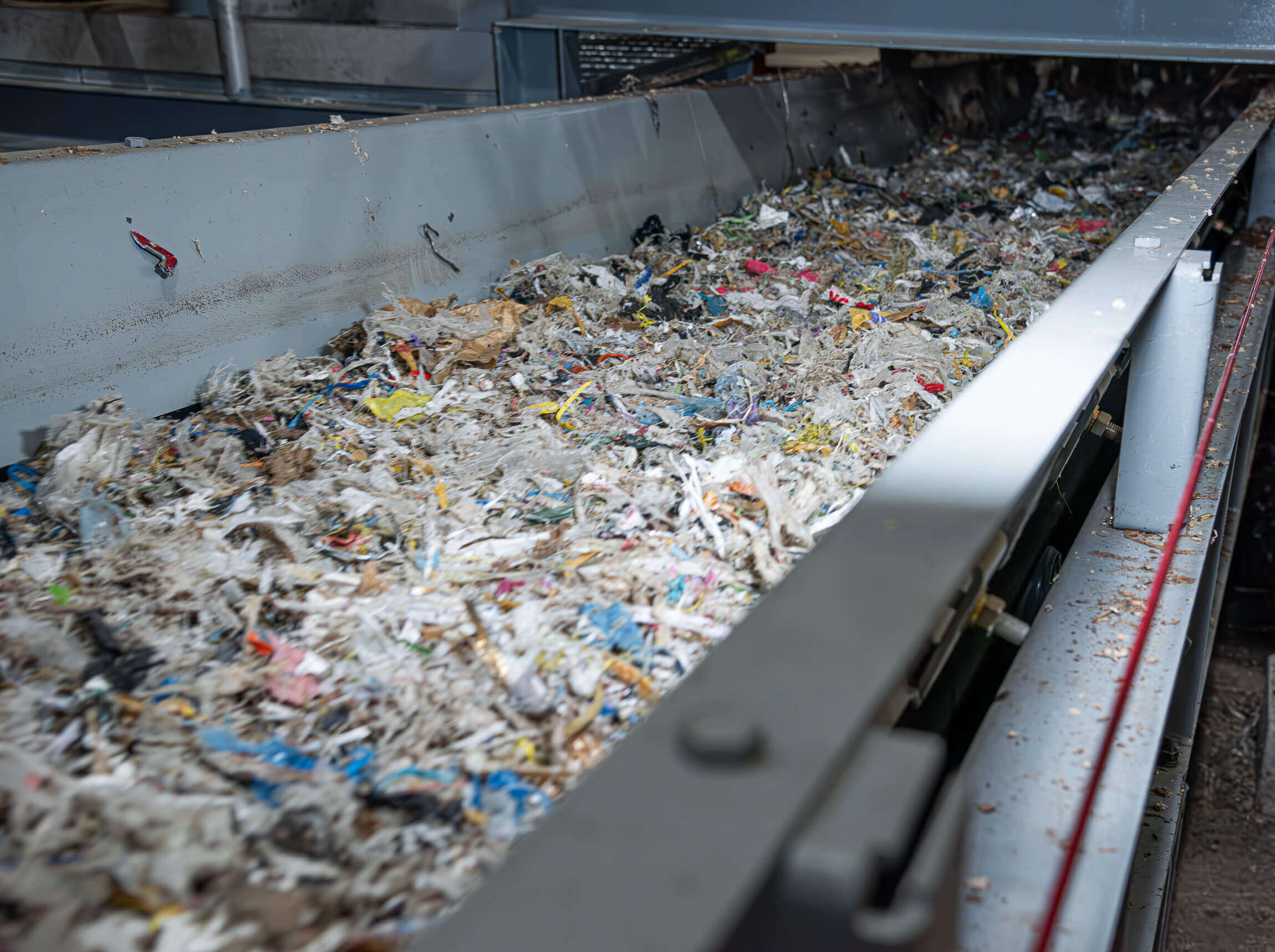 Shredded pulper waste on a conveyor belt