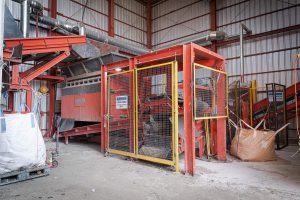 Ein orangener Shredder bei einem Recyclingunternehmen in Südkorea zerkleinert Industrieabfälle.