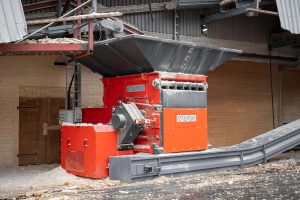 an orange shredder from WEIMA shreds wood waste at a customer in Sweden