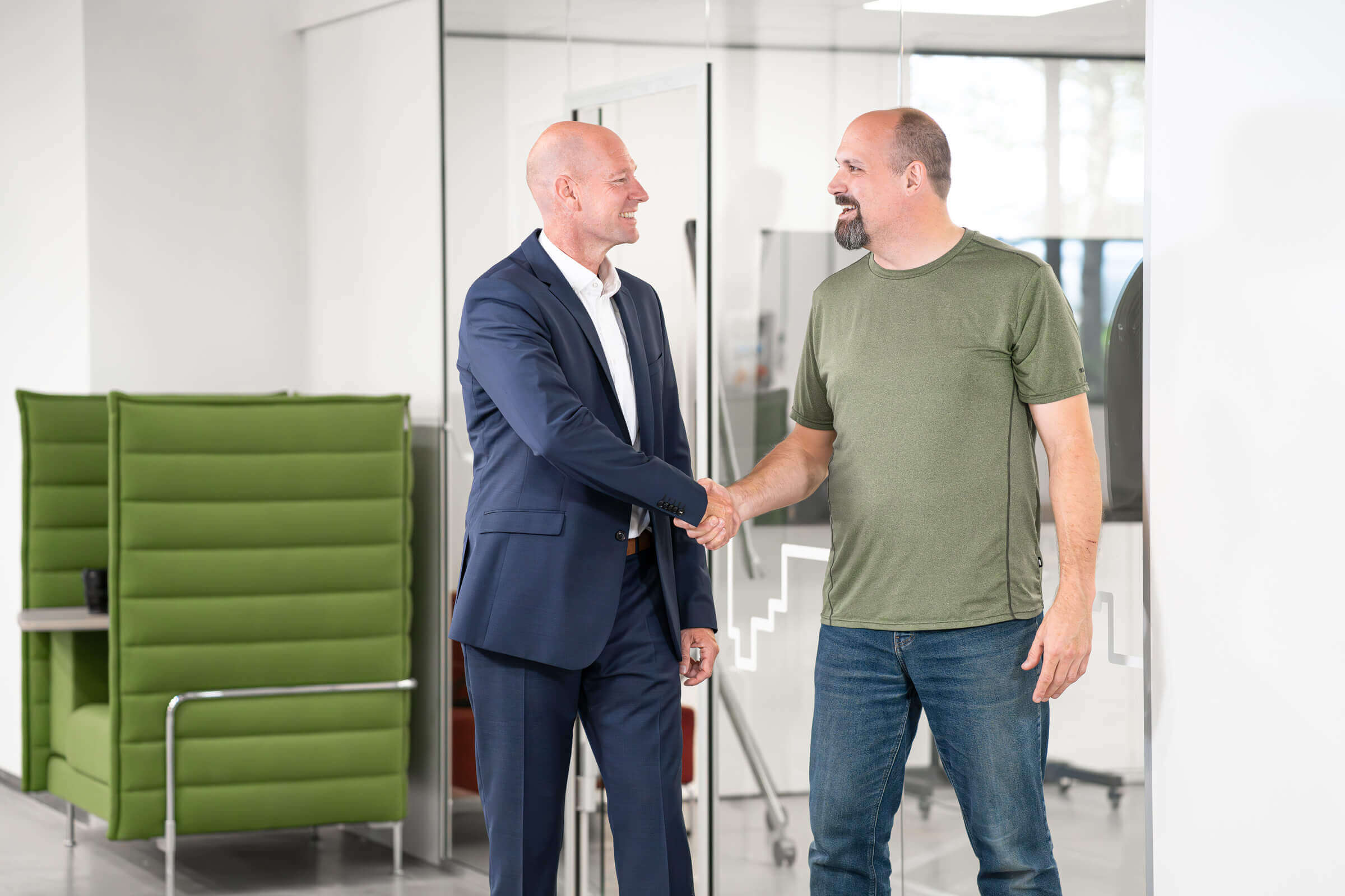 zwei Männer geben sich lächelnd die Hand
