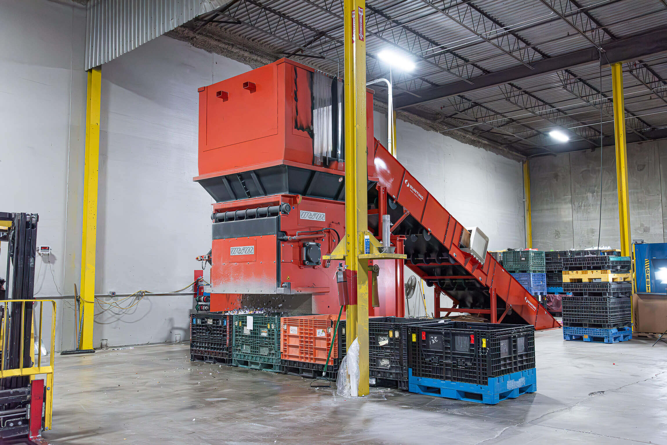 Orangener WEIMA Anfahrbrocken Shredder mit Förderband bei Plastic Recycling, Inc.