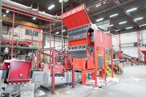 An orange WEIMA W5.18 single-shaft shredder shreds LDPE film at RKW in Hoogstraten, Belgium