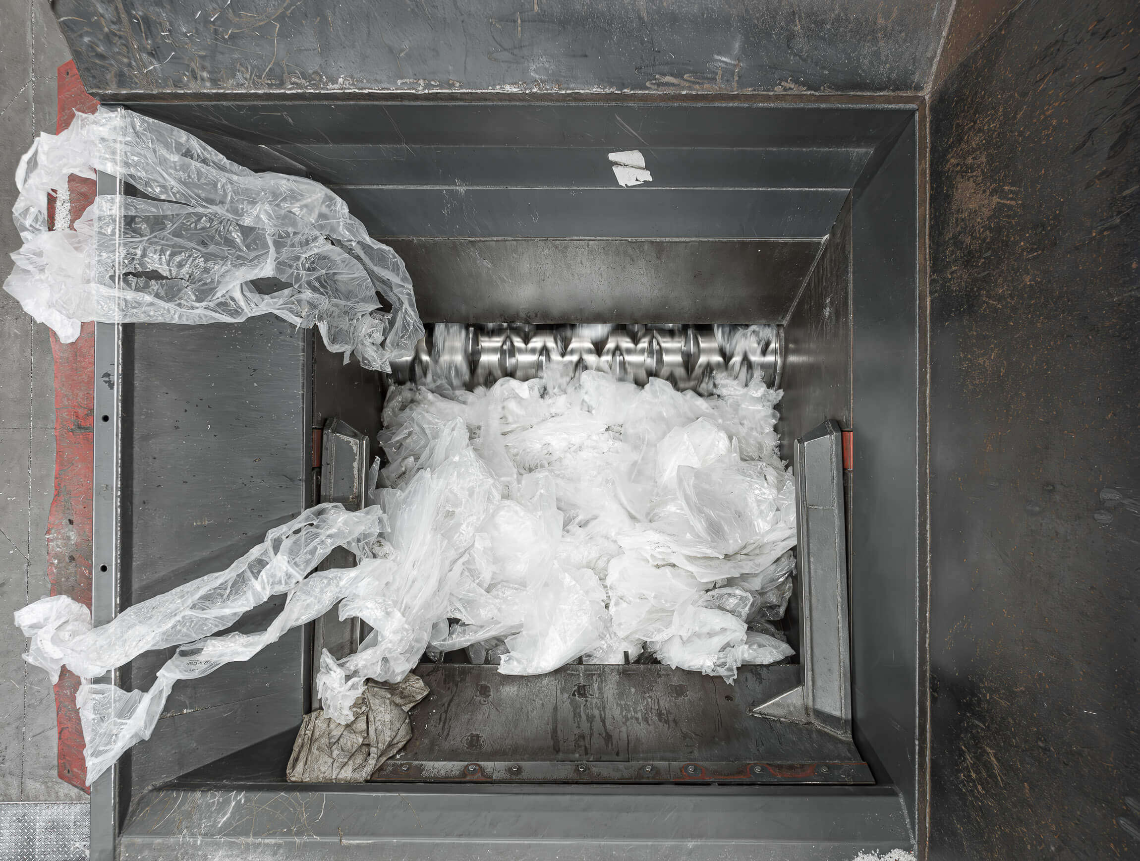 Blick in den Schneideraum eines WEIMA Kunststoff Shredders, der mit einem Rotor transparente LDPE-Folie shreddert
