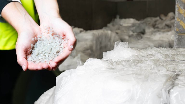 Hands filled with LDPE regranulate, next to it LDPE film in bales