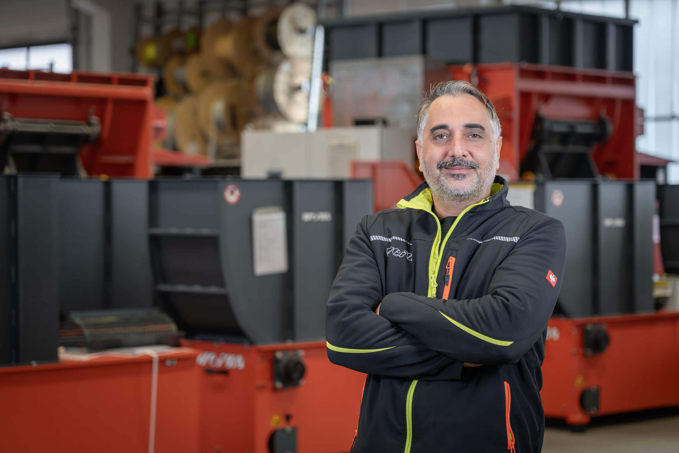 Happy WEIMA employee standing in front of WEIMA WL 4 shredders