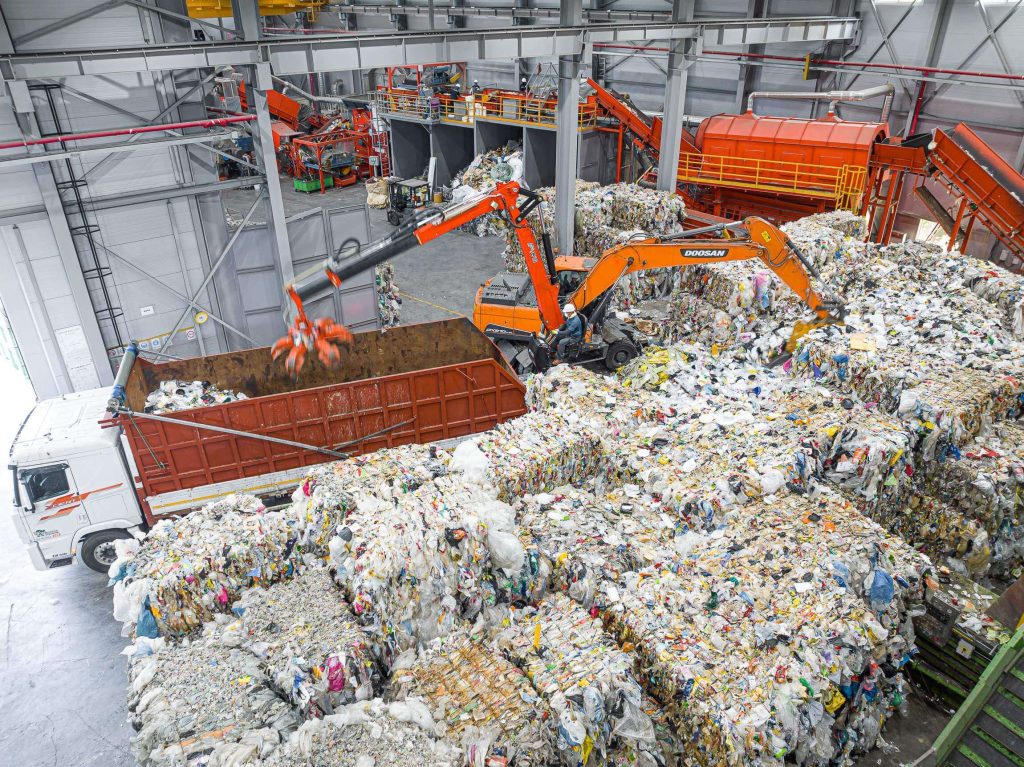 Large accumulation of municipal waste with two excavators transporting it to a recycling plant