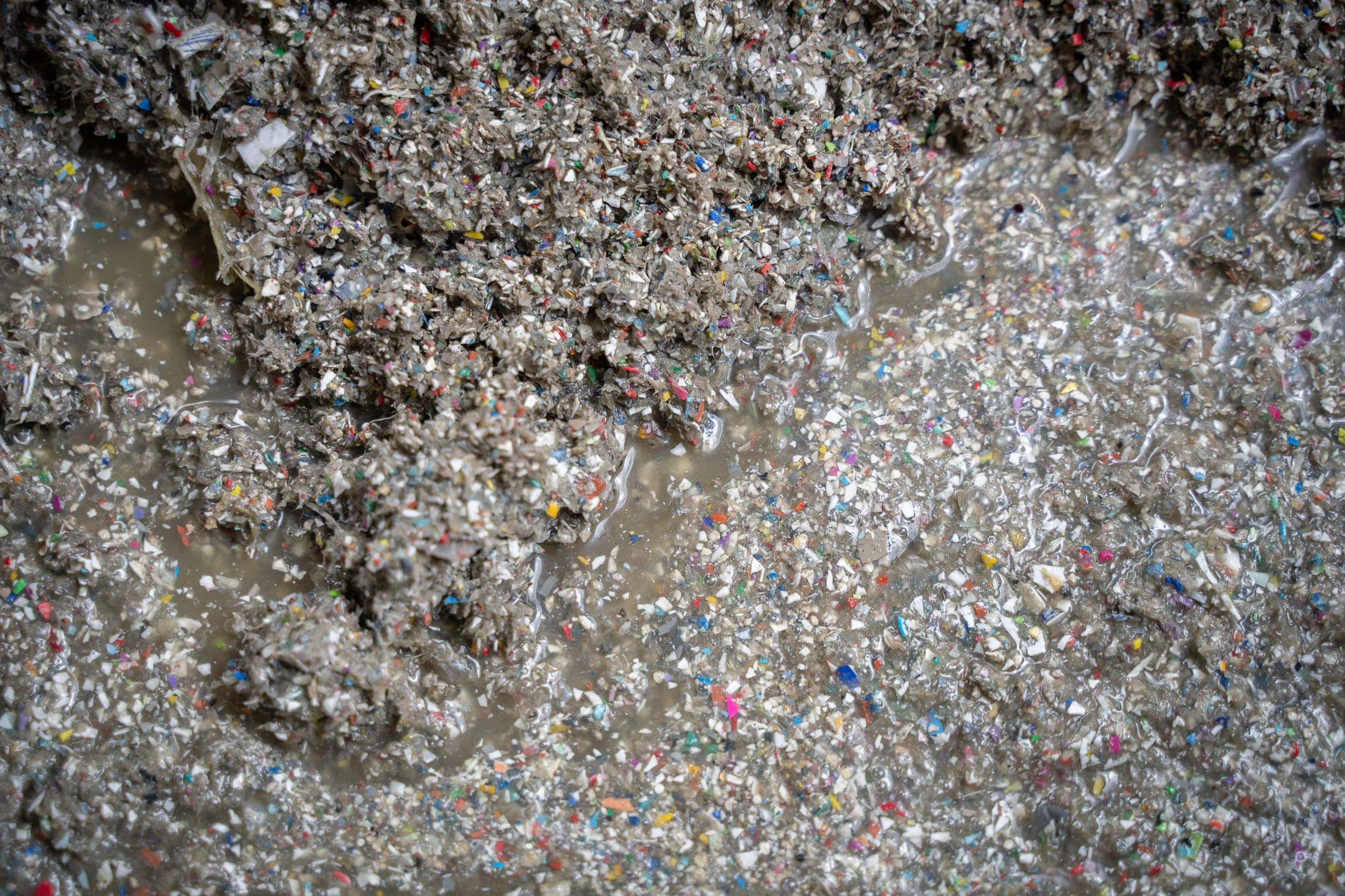 Ein Haufen von nassen Feinanteilen aus Kunststoff in verschiedenen Farben