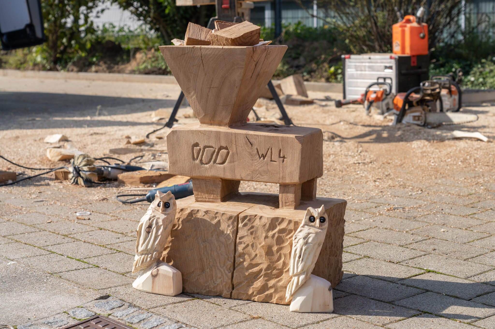 Aus Holz geschnitzte Figuren, zwei Eulen und ein WEIMA Shredder