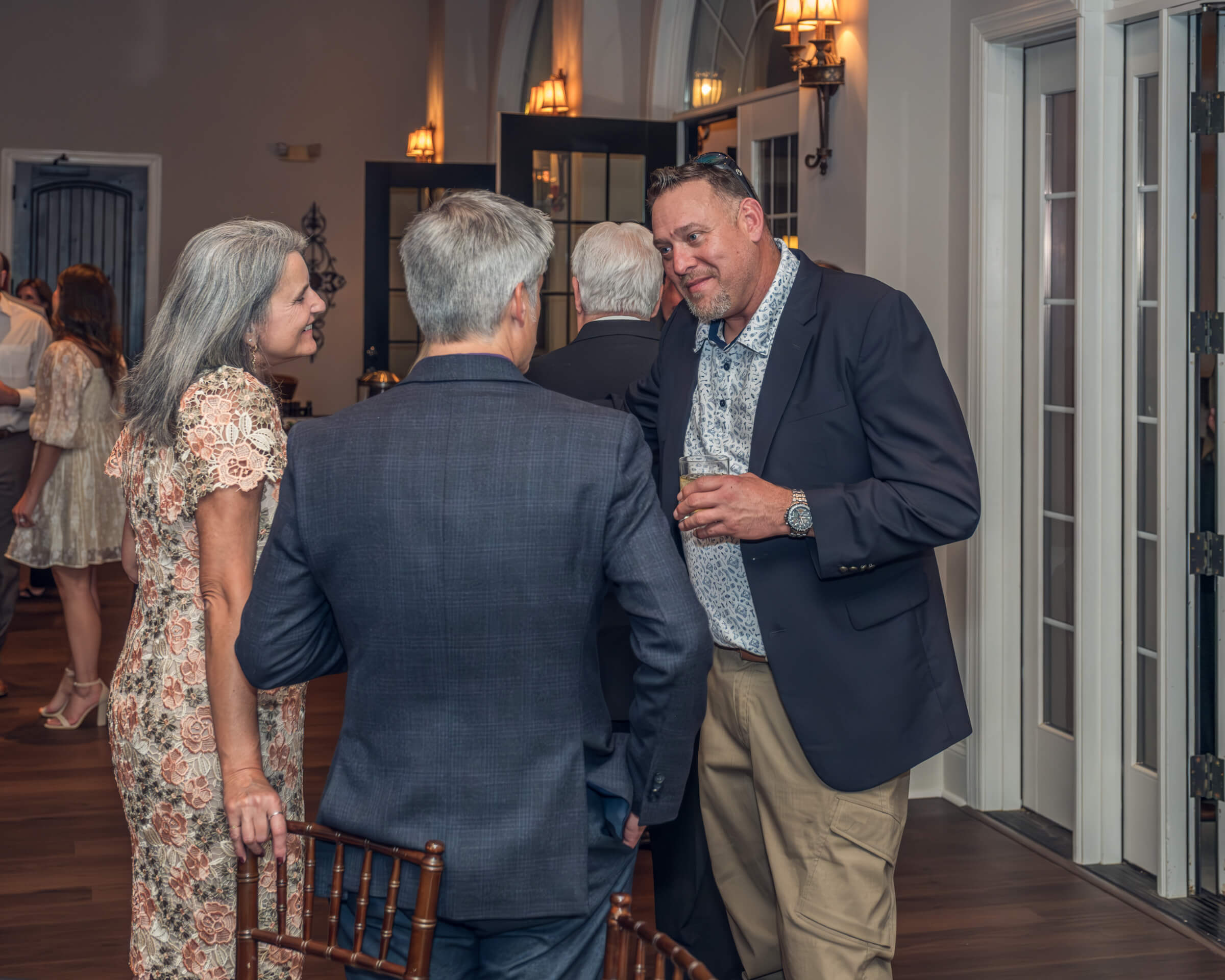 Drei Personen unterhalten sich nett miteinander und stehen dabei in einem Kreis auf einer Feier