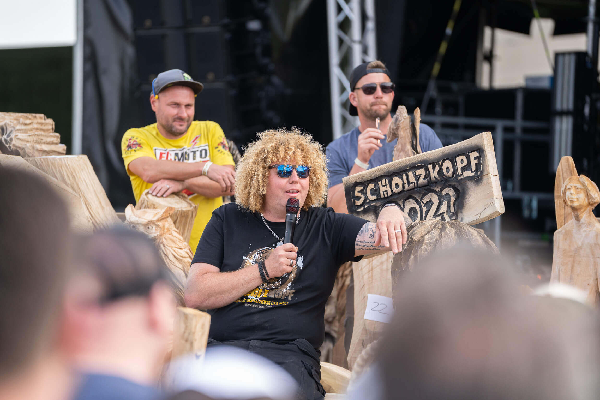 Locke steht auf einer Bühne mit einem Mikro