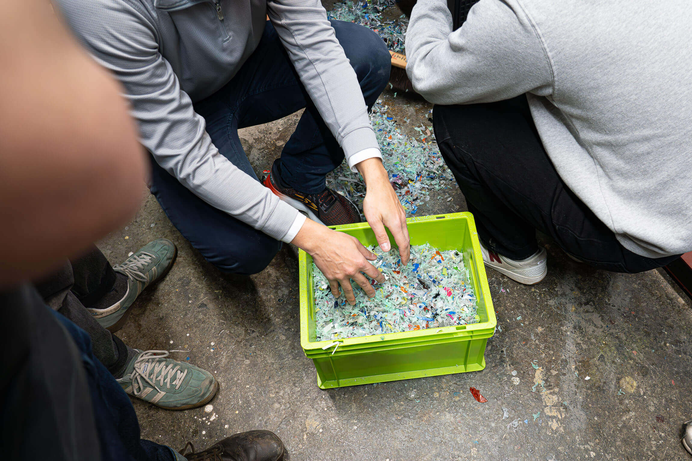 green box with shredded flakes in the floor with student around it