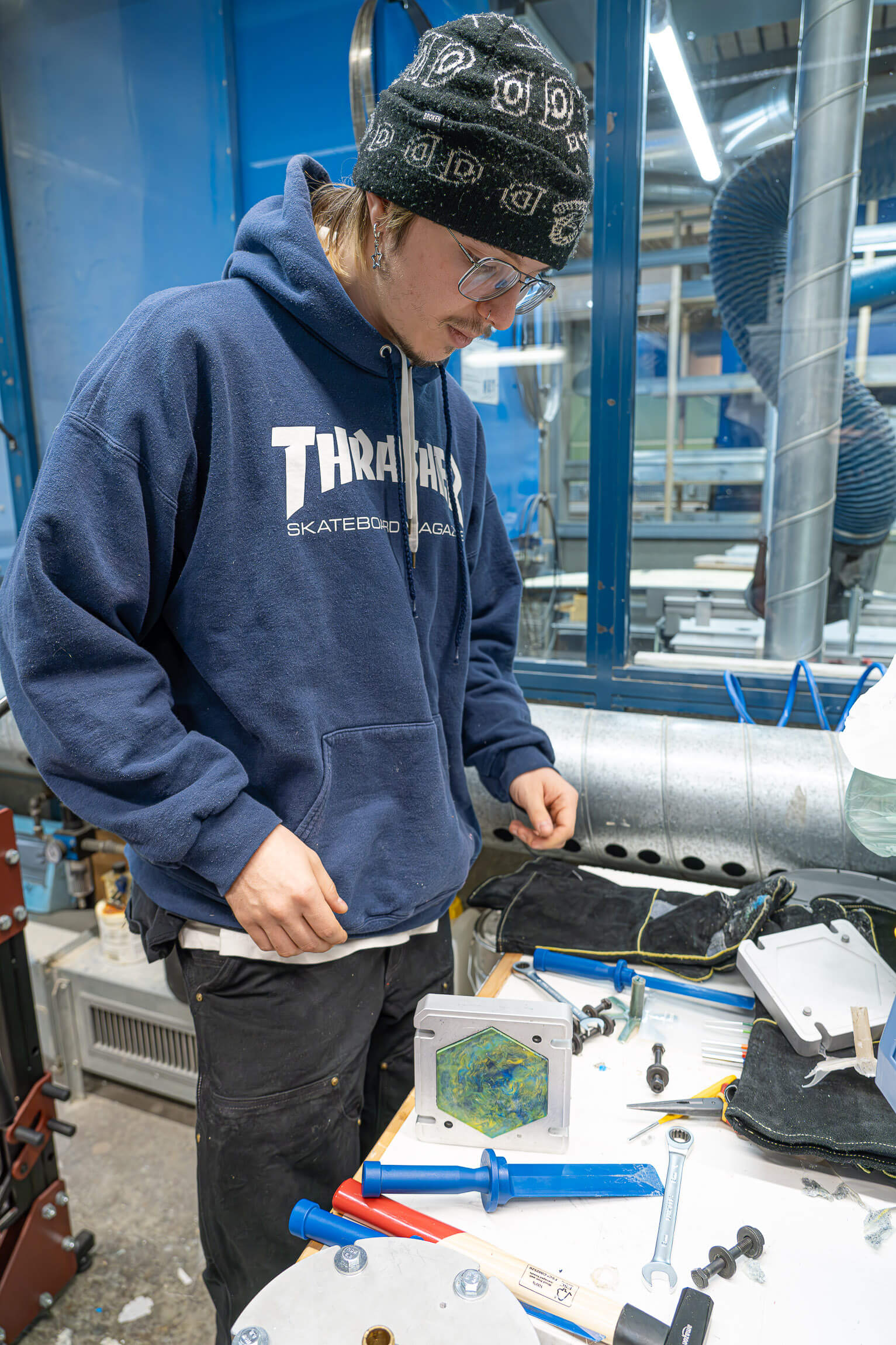Student with tools trying to extract plastic a tile from a mould
