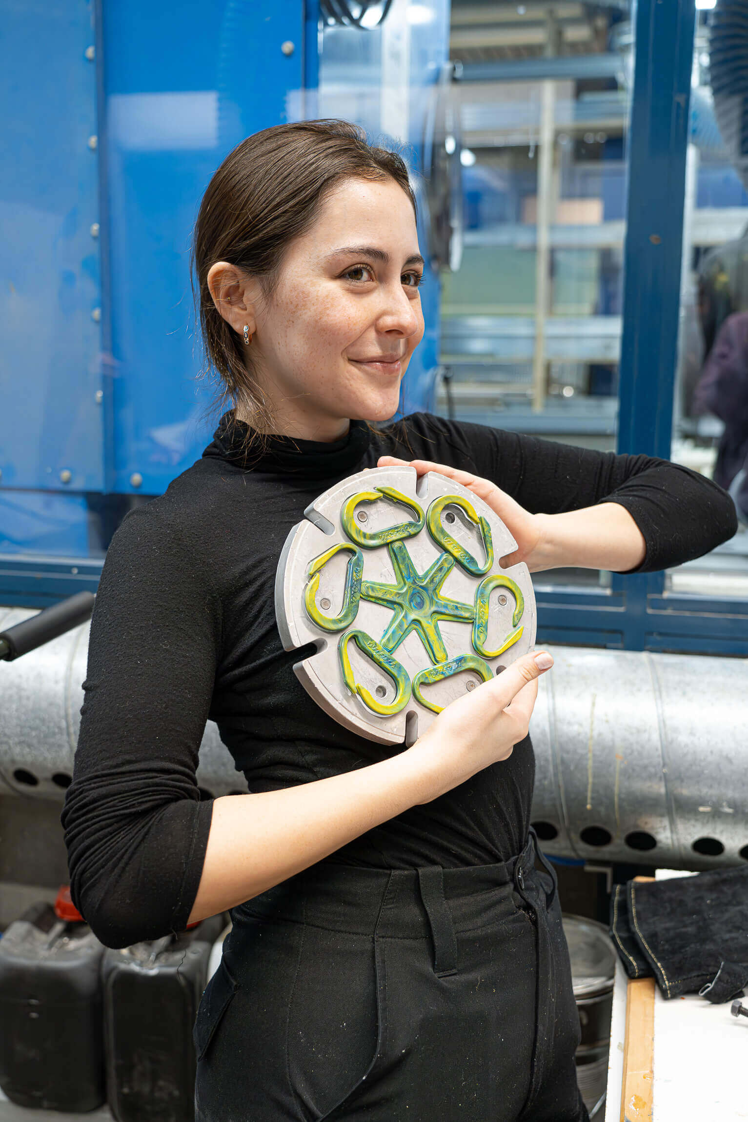 Woman holding an injection mould with plastic carabiners