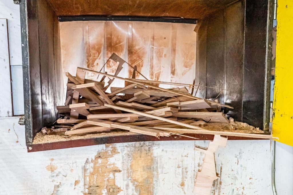 Plywood off-cuts are piled in the shredding chamber prior to being shredded.