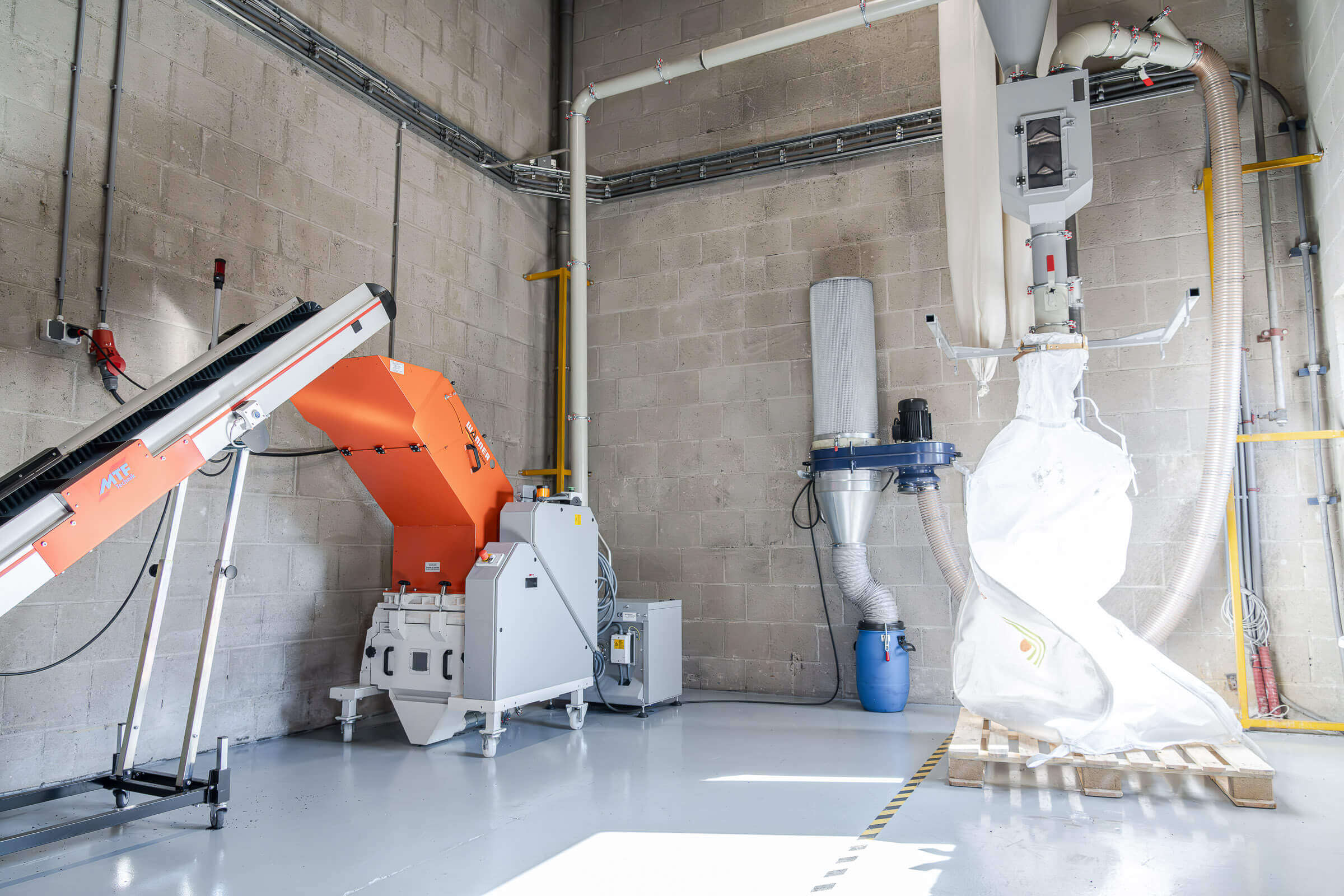 Wanner Dynamic series granulator for the re-shredding of PVC residues, to the right a dust extraction system