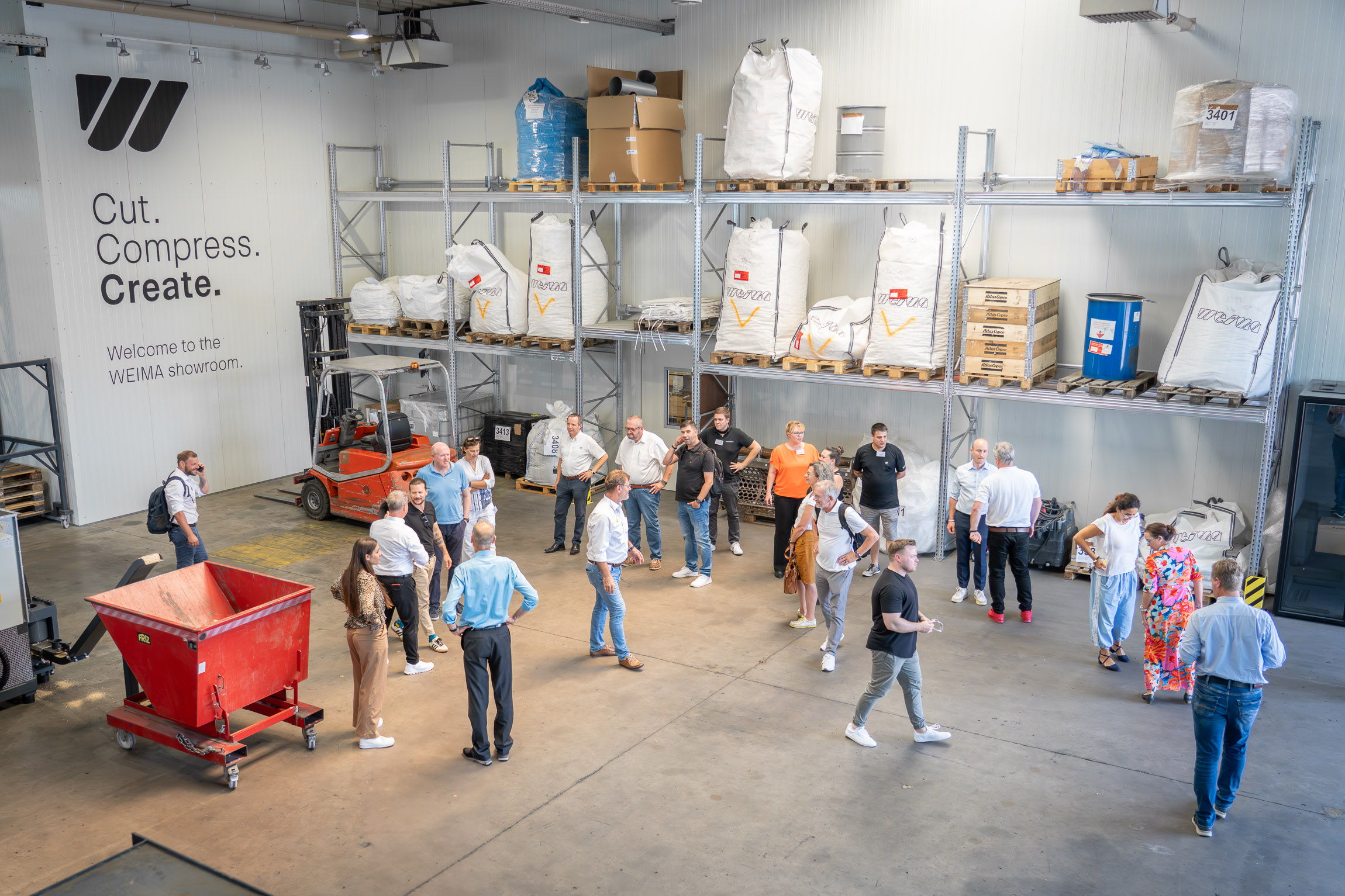 Personen stehen in einer Halle und schauen sich die Maschinen an