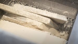 Weiße PU-Platten im Schneidraum eines Shredders werden von dem Rotor zerkleinert.