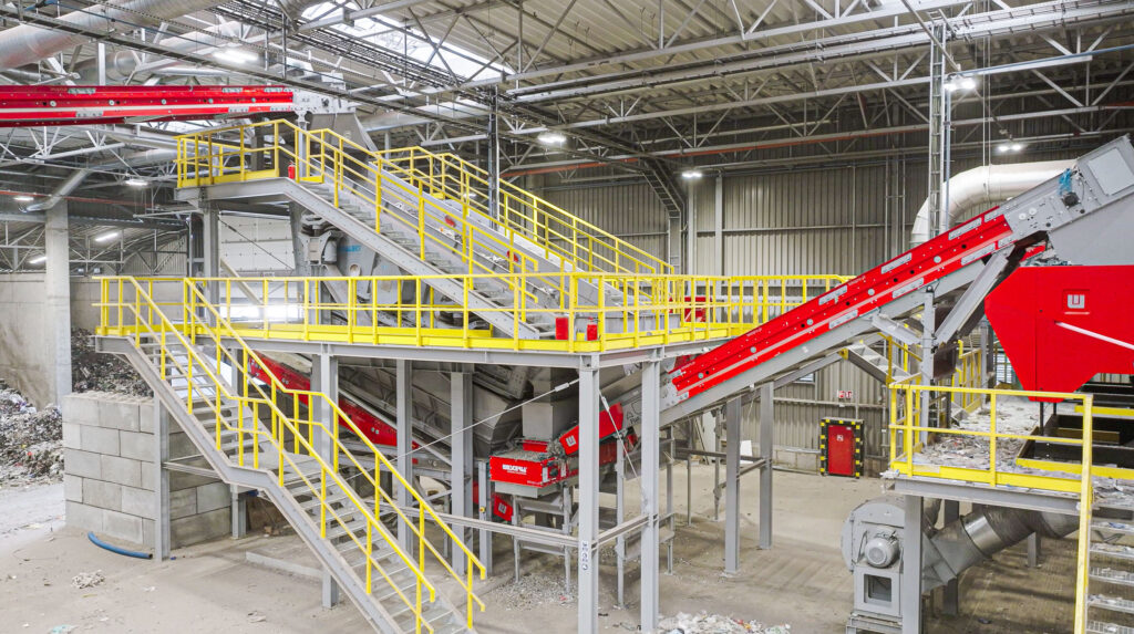 Spaleck Siebmaschine inmitten von Treppen und Förderbändern in einer Produktionshalle
