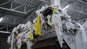 Nahaufnahme einrt mit Müll gefüllte Baggerschaufel in einer Industriehalle