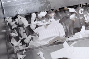 Weiße Kunststoff wird in einem Shredder von dem Rotor zerkleinert