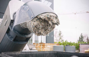 Pressling aus Holz, Papier und Kunststoff Abfällen im Rohr einer WEIMA C.200 Entwässerungspresse