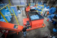 Paper shredder from WEIMA in industrial hall with conveyor belts and blue paper waste
