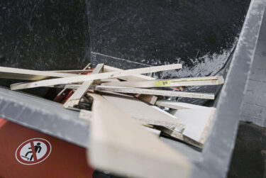 a top-down view into a machine hopper filled with wood waste pieces