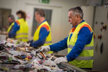 Workers sort waste in a recycling plant