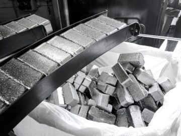 Hochverdichtete Aluminium Briketts werden aus der Brikettierpresse ausgestoßen