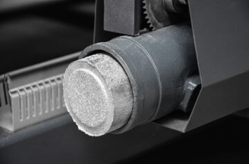 Rundes Alubrikett wird aus der Brikettierpresse gepresst
