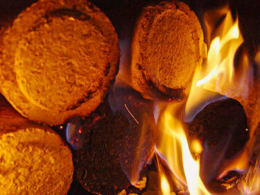 Burning round wood briquettes in a wood burning oven