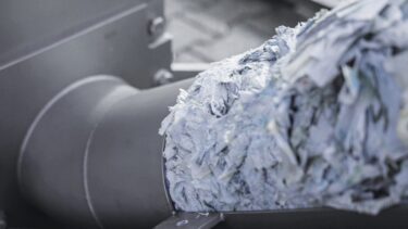Presslinge aus Etiketten werden aus der Maschine geschoben
